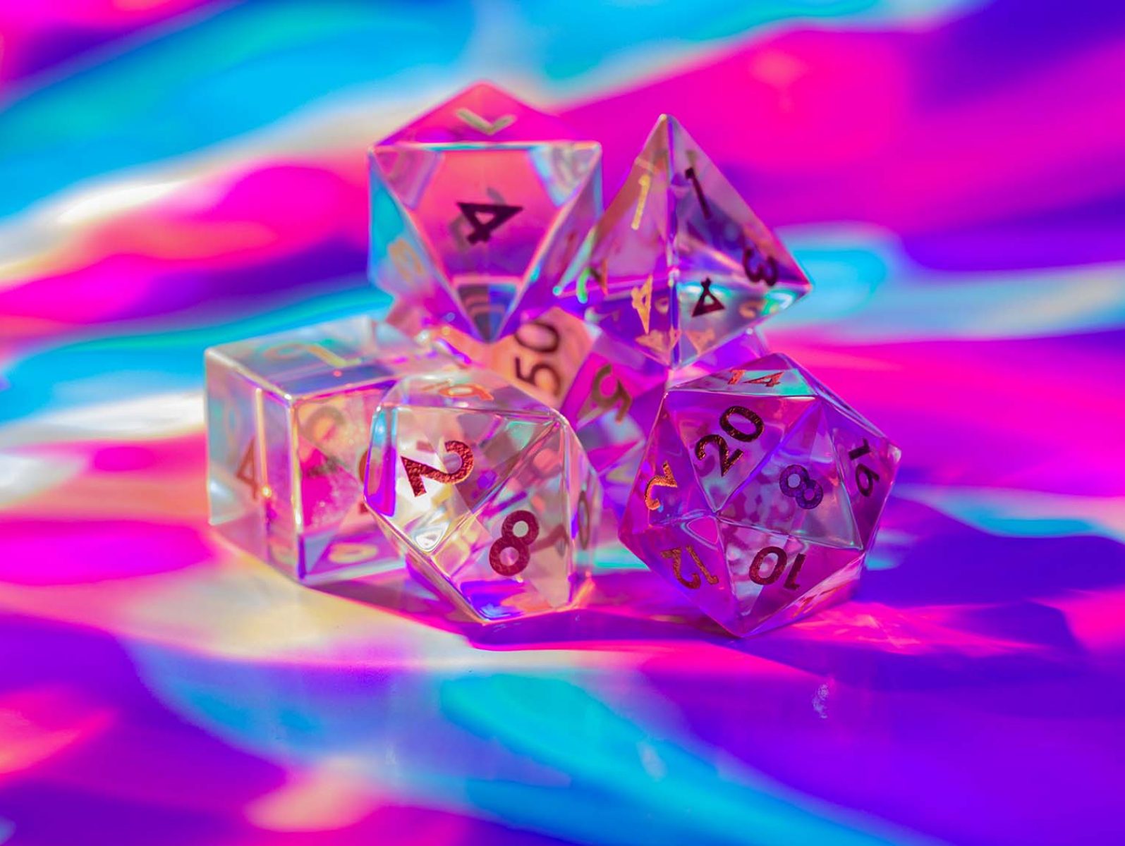 RPG dice against a pink, blue, and purple background