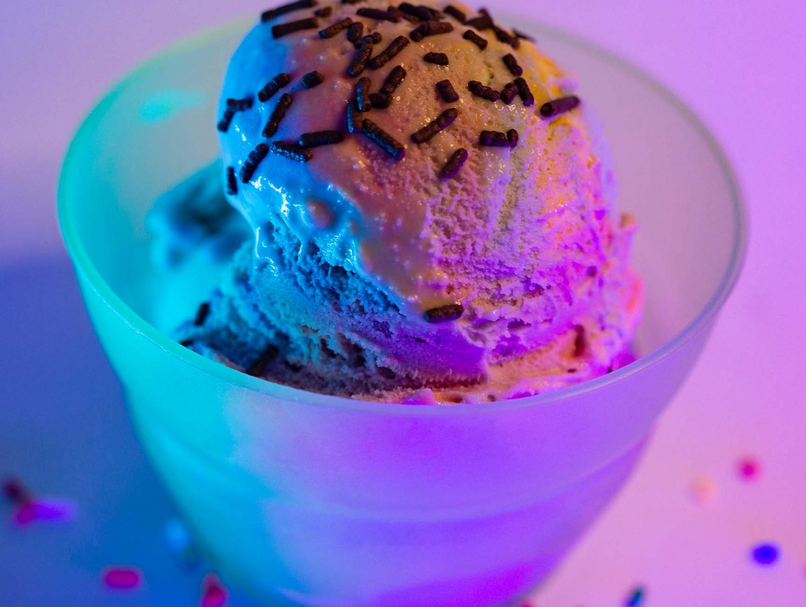 Rainbow ice-cream lit with blue and pink neon lights